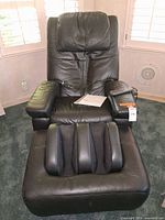 Full front view of black leather massage chair and foot massager ottoman