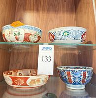 Four bowls on glass shelf showing overall lot