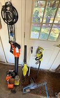 Group shot of power tools and cords against door