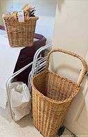 Tall wicker hamper, drying rack, sorter cart frame, bag and basket visible