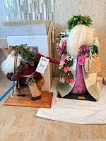 Both Lynn Haney Santa figures side by side on floor