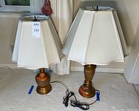 Pair of brass table lamps with shades and cords visible