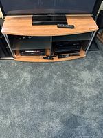 Front view of TV stand with electronics on top showing overall appearance
