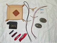 Overview of lot showing bolo ties, buckle, knives, tray, cufflinks