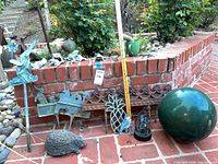 Group of yard stakes, hedgehog, fence border, gazing ball and ruler for scale