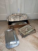 Group of five metal serving pieces on floor