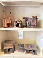 Group shot of all six terracotta village buildings on shelves