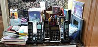 Front view of four Panasonic handsets, main base, and surrounding office supplies
