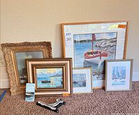 Group of framed artworks and easel stands