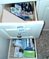 Drawer showing GUM flossers, face serum bottles, lower drawer with Johnson’s powder, back scrub boxes