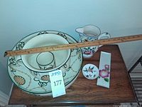 Top view of all items on table showing bowls, pitcher, small dish, rectangular tray and measuring stick