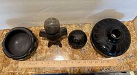 Top view of all four blackware pieces aligned by a ruler