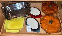 Drawer view showing stainless pan, yellow baker, two pumpkin cocottes, red and blue gratin dishes