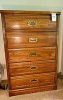 Front view showing five drawers with brass pulls