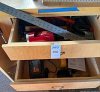 Open drawers showing RIDGID charger, battery, manual, framing square, clipper handle