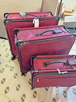 Three burgundy Tutto suitcases showing relative sizes