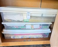 Stacked plastic totes containing craft supplies