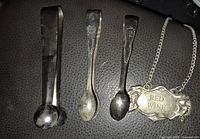 Three sugar tongs and decanter label overview