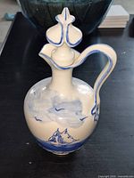 Front view of pitcher displaying ship motif and stopper in place