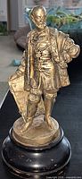 front view of gilt metal figurine on wood base