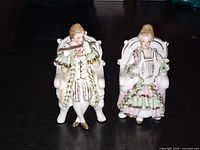 Front view of both seated musician figurines