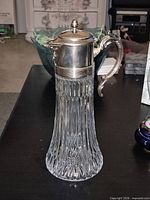 Full view of glass pitcher with metal components