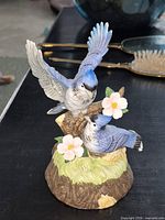 Front view of resin/ceramic bluebird pair on floral stump base