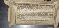 Khaki cloth-wrapped Canadian field dressing showing full instructions text
