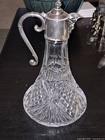 Full view of cut glass decanter with silver mount