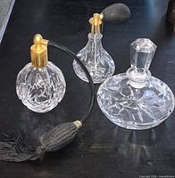 Full set of three cut crystal perfume pieces on black surface