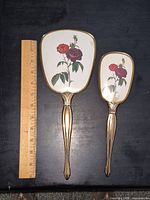 Front view showing floral backs and ruler for scale