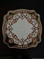 Front view of square plate displaying full Imari-style pattern and gilt trim