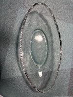 Top view of clear oval pressed glass bowl showing scalloped edge