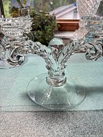 Front view of Cambridge Glass Martha double candlestick showing scroll arms and round base.