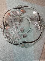 Top view of clear glass plate showing teardrop rim and poppy etch