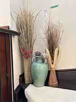 Vase with handles and two faux floral bundles on stair landing