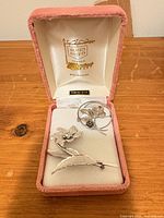 Both brooches displayed inside Bond Boyd presentation box, lid showing logo