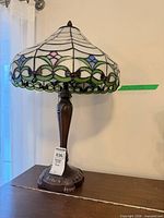 Side view of Tiffany-style table lamp showing full stained glass shade pattern and bronze base