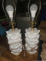 Front view of two matching white Safavieh lamps with bulbs and cords