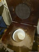 Overall view of open wooden commode chair showing seat opening