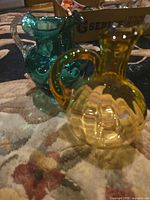 Amber and teal glass vessels side by side