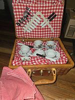 Basket open showing tea set, utensils, napkins