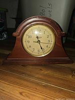 Front view of wooden mantel clock showing dial and case