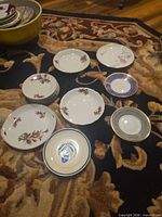 Assorted porcelain plates and saucers laid out showing patterns and quantity