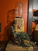 Full view of mason jar lamp on wood base with decorative garland