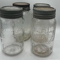 Four clear Crown Made in Canada mason jars with glass lids and zinc rings