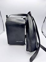 Side view of Amprobe tester inside leather case showing strap and Amprobe logo