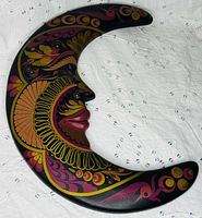 front view of crescent moon wall hanging showing hand-painted folk art design