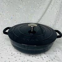 Top view of dark blue COOK sauté pan with lid and knob