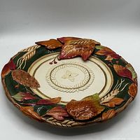 Front view of decorative ceramic plate with autumn leaf motif